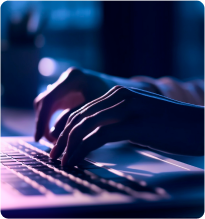 Pessoa digitando no teclado de um computador, com foco nas mãos sobre as teclas.
